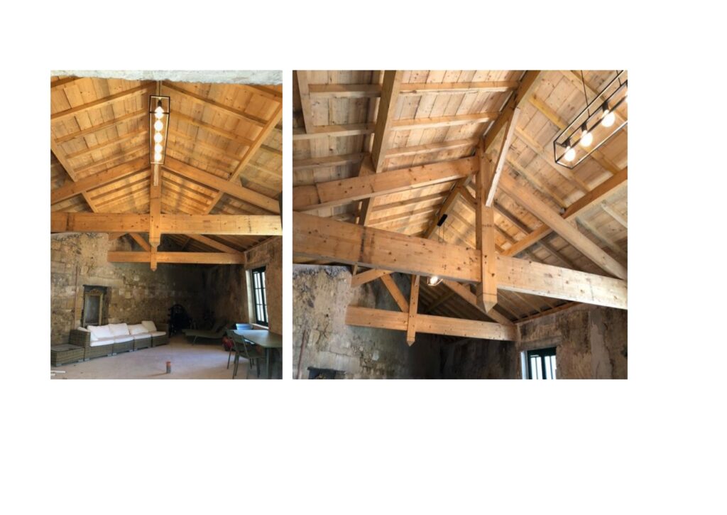 Charpente en bois apparente et design rustique chic Intérieur rustique avec charpente bois apparente, murs en pierre, canapé blanc et luminaires modernes design.